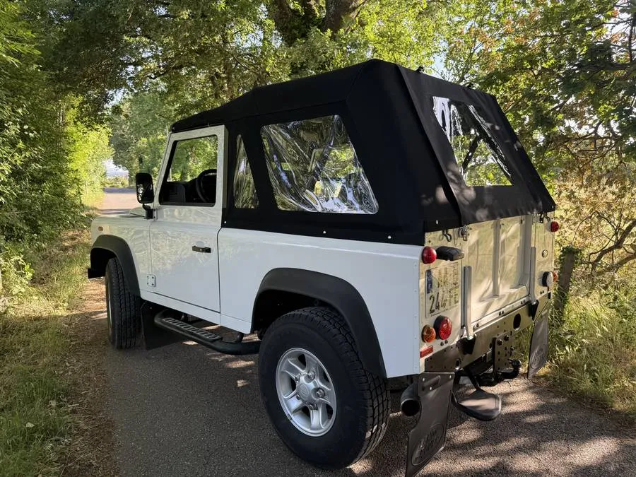 Capote sur mesure noire terminée sur un Land Rover Defender blanc