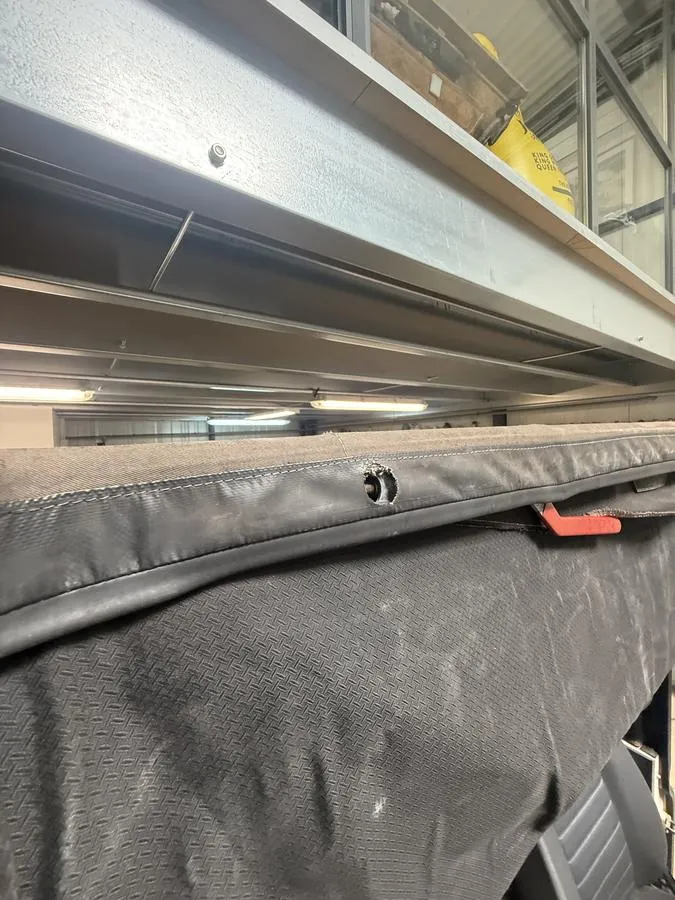 Toile de capote d’origine usée et déposée sur l’armature du Land Rover Defender