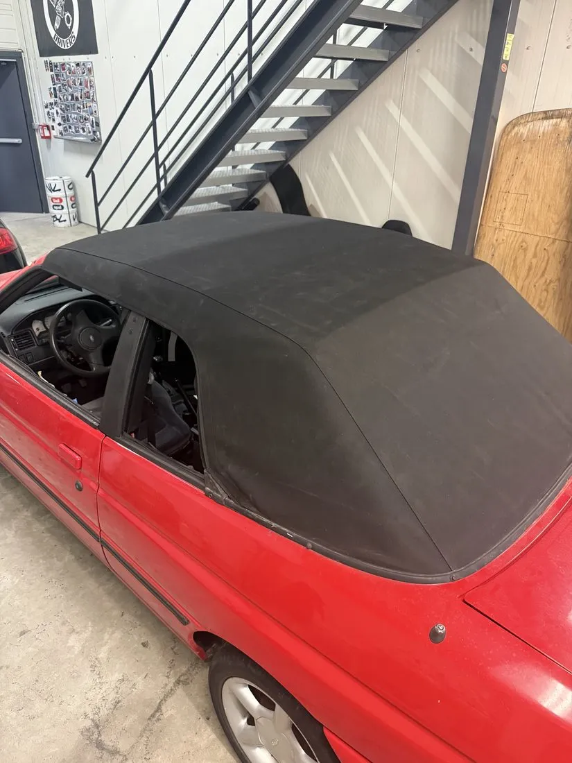Ford Escort cabriolet rouge avec sa capote noire refaite, vue de profil