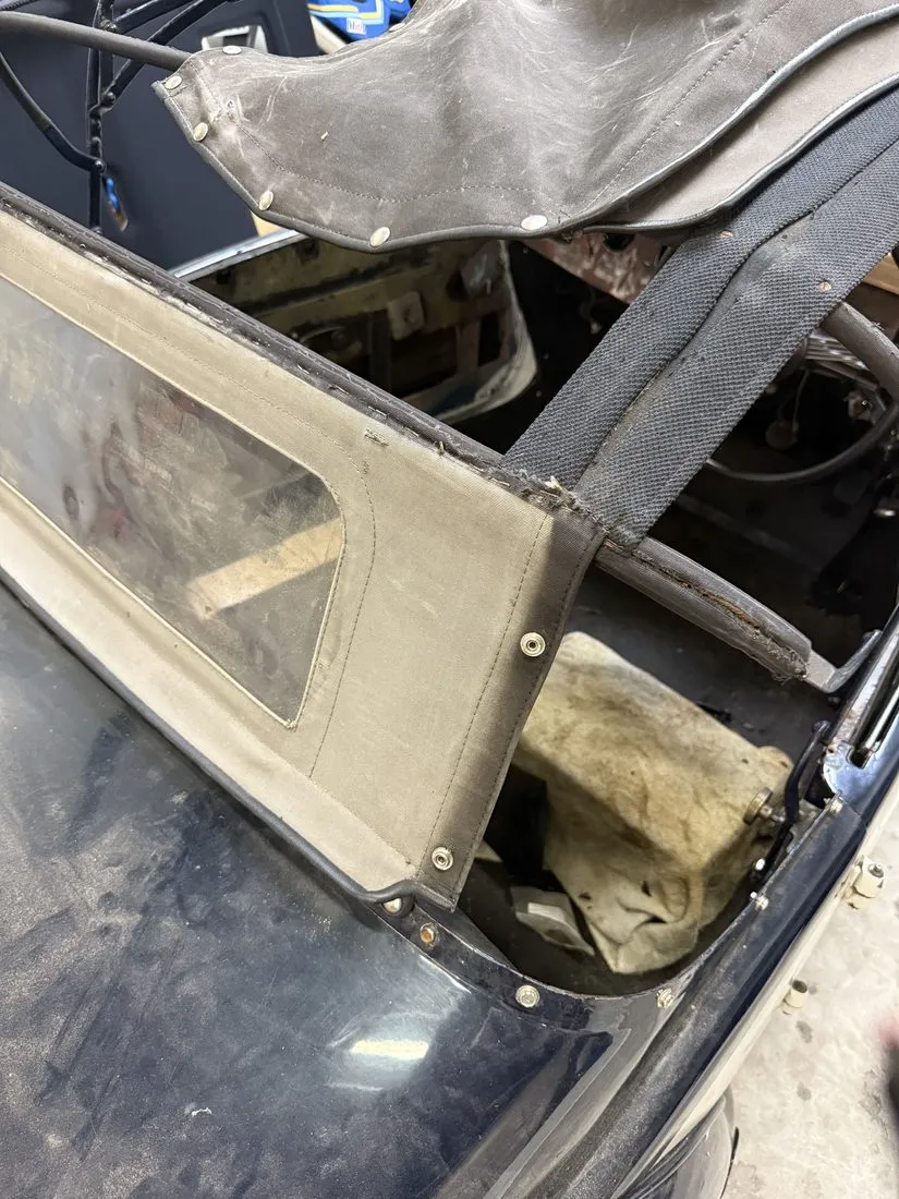 Ancienne toile de capote raidie et déchirée sur l’armature du cabriolet Hotchkiss