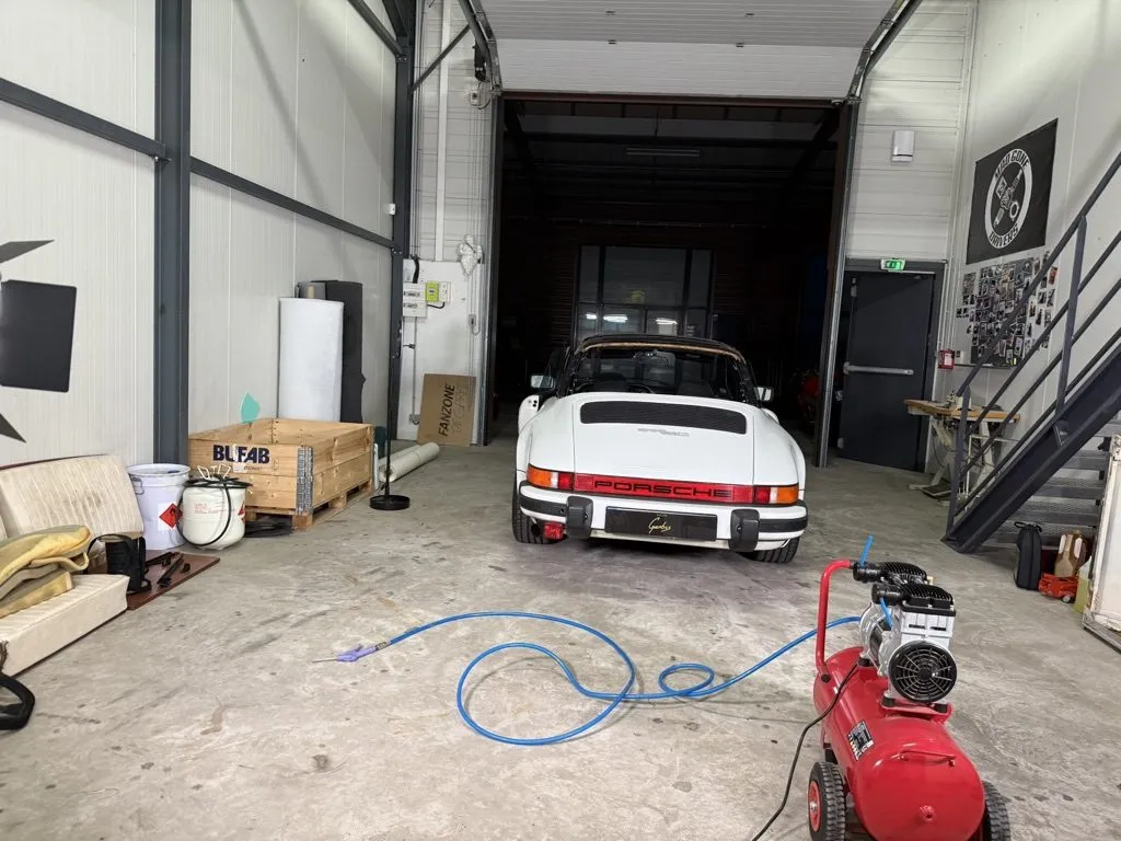 Porsche 911 SC blanche dans l’atelier avant la réfection de sa capote
