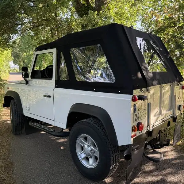 Land Rover Defender X-trem avec sa capote sur mesure neuve, sur une route de campagne