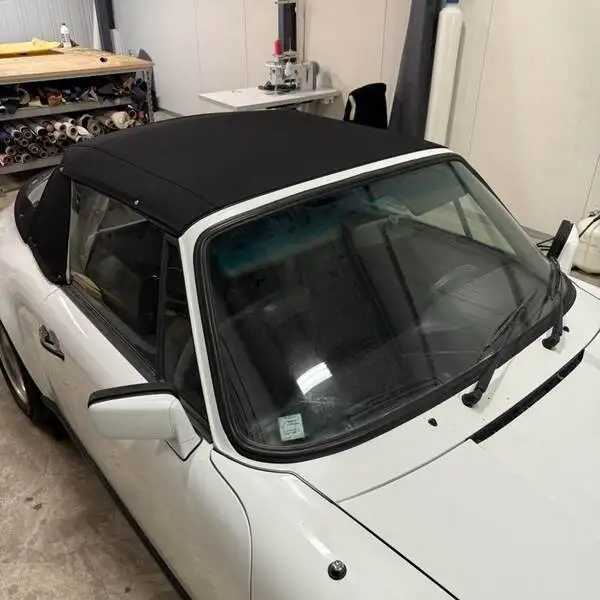 Porsche 911 SC cabriolet blanche avec sa capote neuve posée dans l'atelier