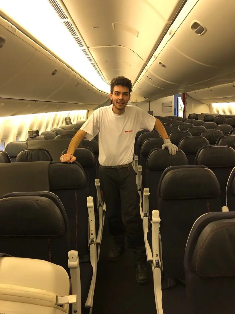 Charles Bailly dans la cabine d'un avion de ligne, entre les rangées de sièges, pendant sa première année de Tour de France