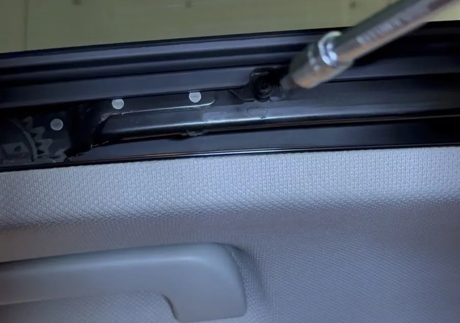 Vis du rail de toit ouvrant d’Audi A1 défaite au-dessus du tissu de ciel de toit gris à relief
