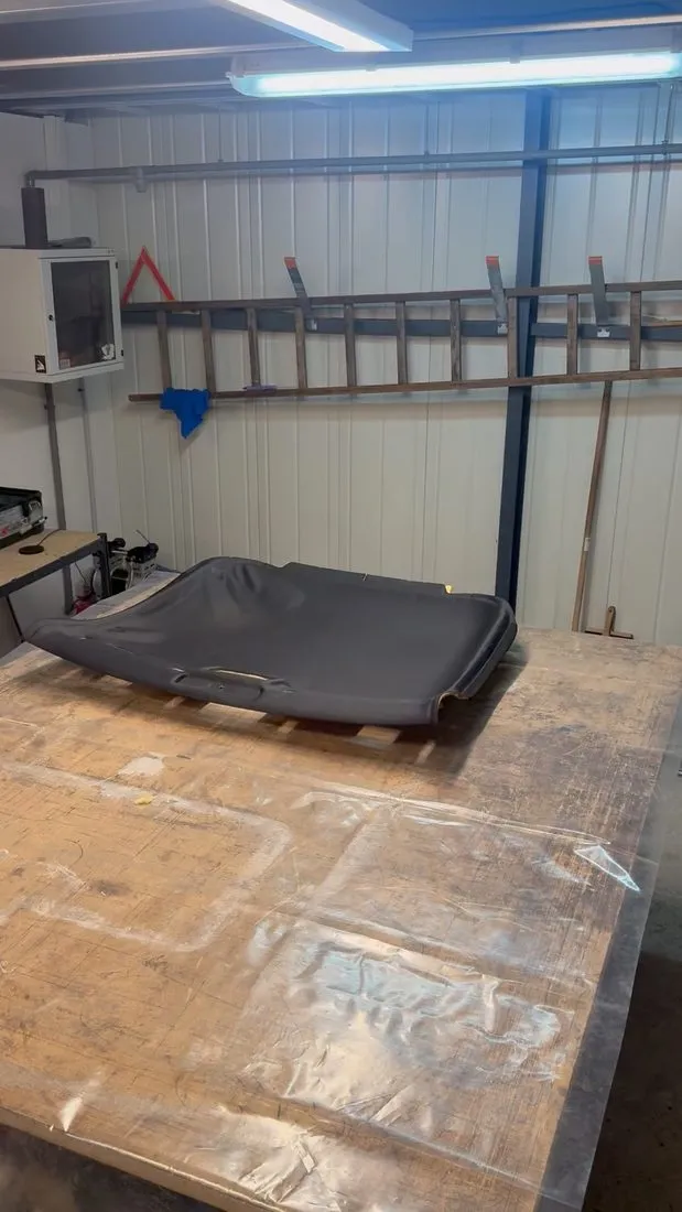 Coque de ciel de toit d’Audi TT en cours de garnissage sur l’établi de l’atelier