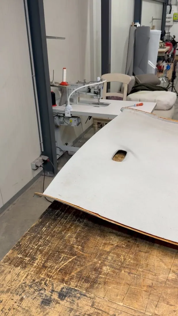 Coque de ciel de toit déposée d’une Mercedes W210, posée à plat sur l’établi de l’atelier