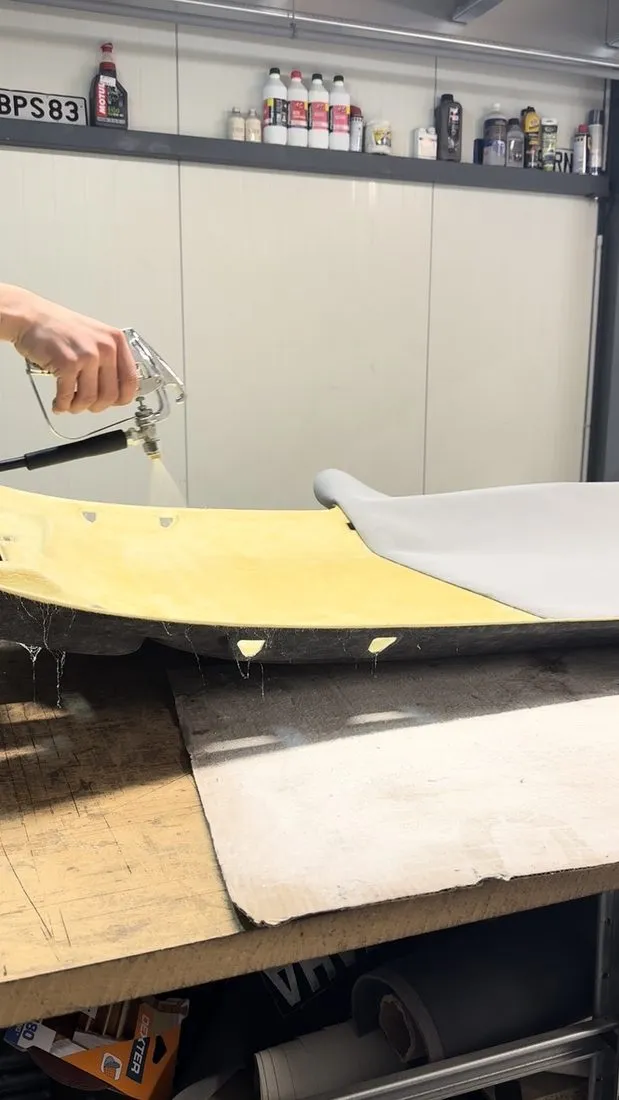 Encollage au pistolet d’une coque de ciel de toit posée sur l’établi de l’atelier