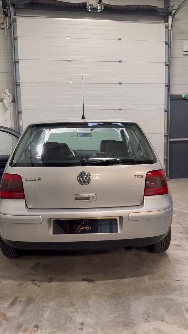 Volkswagen Golf 4 grise garée dans l’atelier avant la dépose du ciel de toit