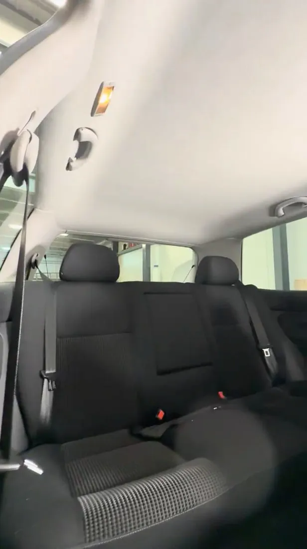 Ciel de toit refait et tendu dans l’habitacle d’une voiture, vu depuis la banquette arrière
