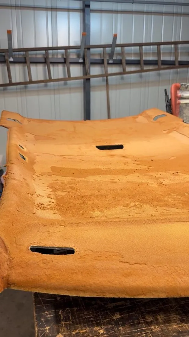 Coque de ciel de toit de Volvo avec sa mousse d’origine désagrégée, posée sur l’établi