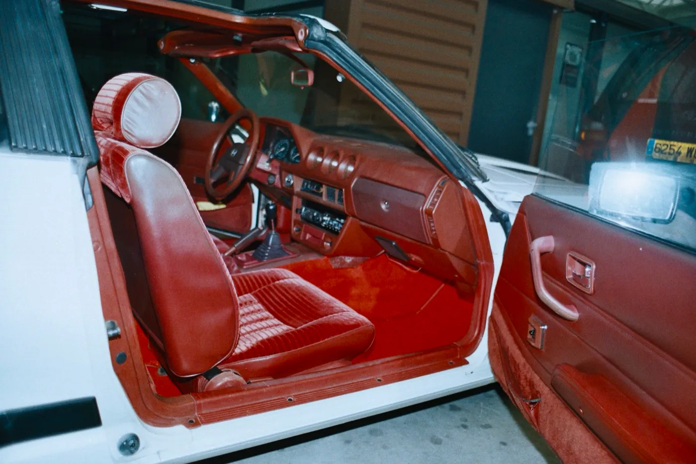 Habitacle de Datsun 280 ZX terminé, moquette et sellerie rouges posées, vue depuis la portière conducteur