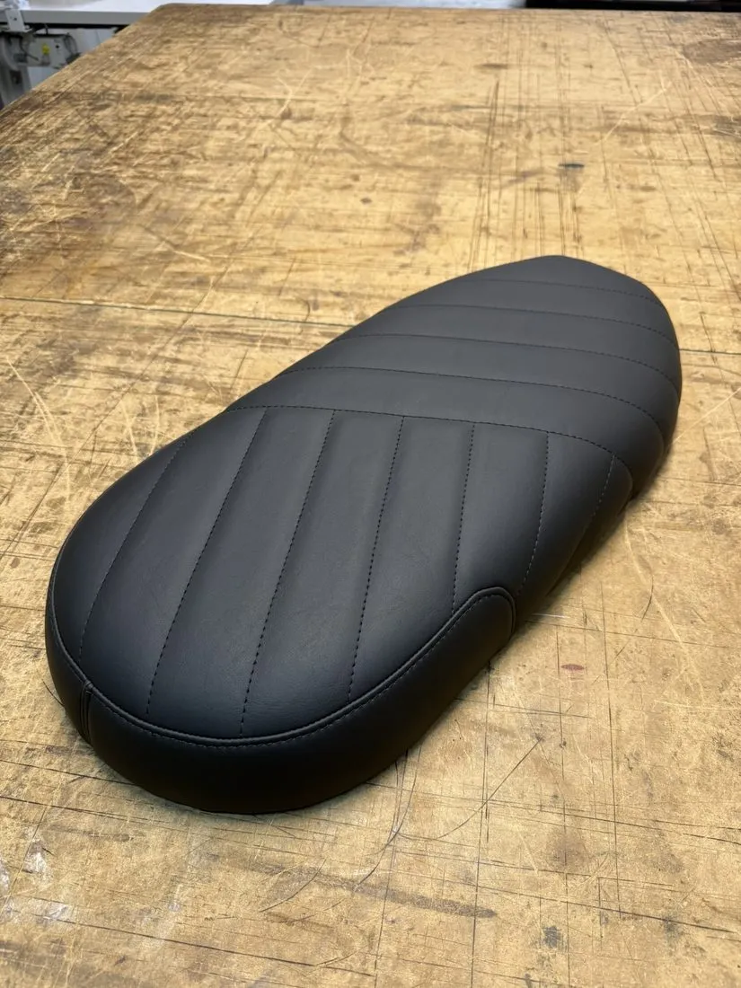 Selle moto matelassée terminée, housse cousue et tendue sur la mousse refaite