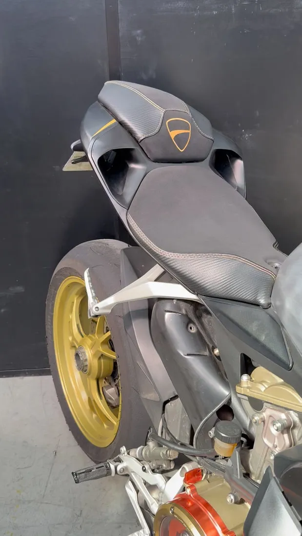 Selle de Ducati Panigale refaite, assise en simili agrippant et flancs façon carbone avec surpiqûres claires