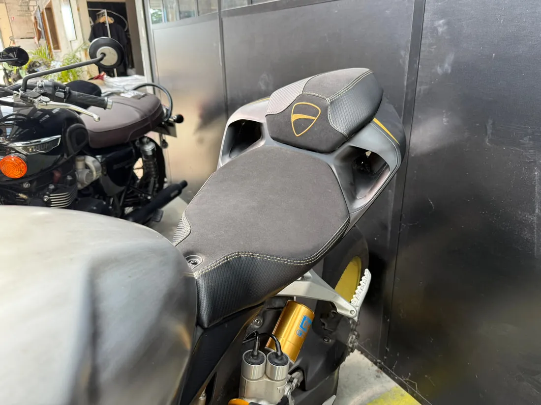 Selle de Ducati Panigale montée sur la moto, dans l’atelier, avec les fourches Öhlins dorées
