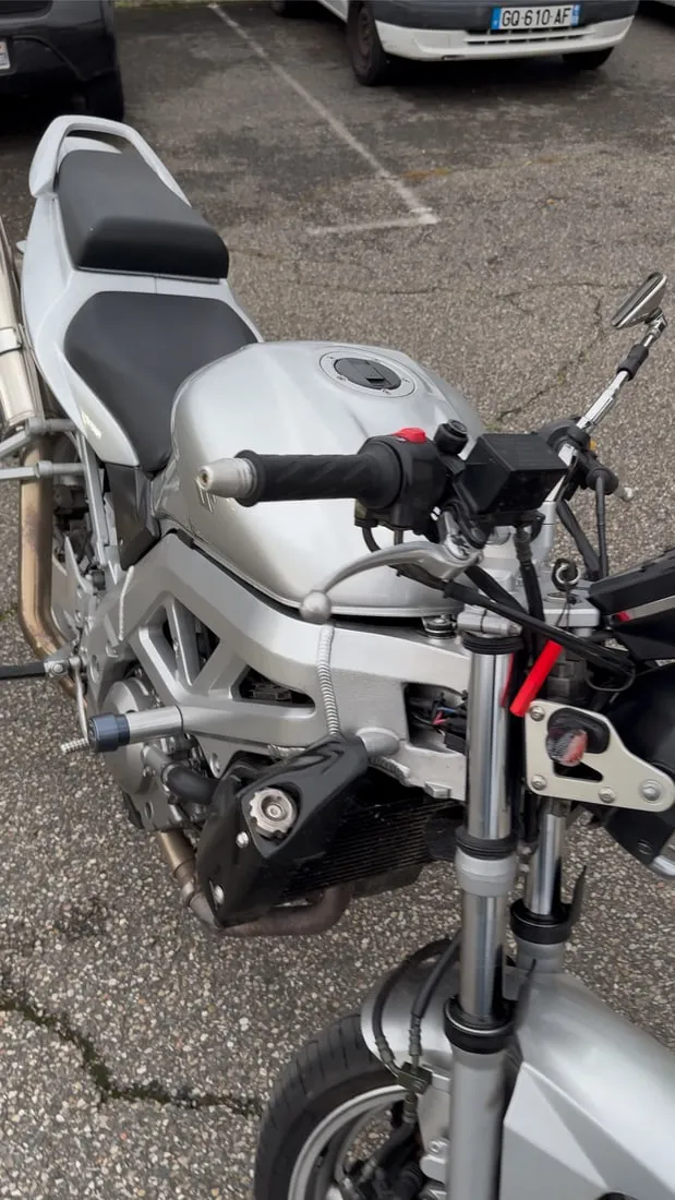 Suzuki SV 650 grise garée devant l’atelier, avant le passage de la selle sur l’établi