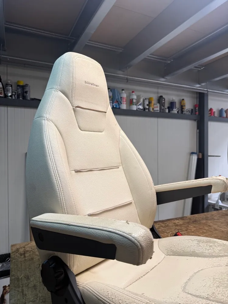 Siège de camping-car Bürstner dont le dossier est regarni en simili crème, l’assise d’origine encore en place, craquelée et pelée